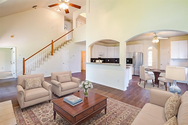 3550 Beacons Vw, Friendswood, TX 77546 - living room featuring ceiling fan, arched walkways, high vaulted ceiling, dark wood finished floors, and stairway