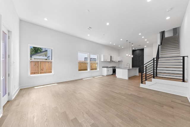 4710 Gunter St, Houston, TX 77020 - unfurnished living room with a sink, stairway, light wood finished floors, recessed lighting, and baseboards