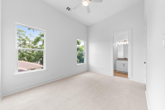 4710 Gunter St, Houston, TX 77020 - unfurnished bedroom with light carpet, baseboards, vaulted ceiling, connected bathroom, and ceiling fan