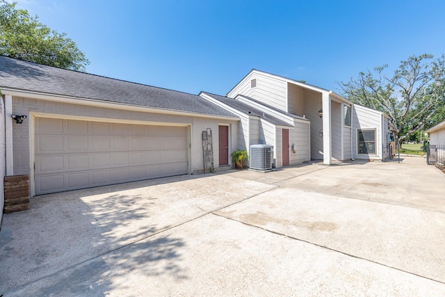 20107 Sunny Shores Dr, Humble, TX 77346 - mid-century home with concrete driveway, central AC unit, a garage, and brick siding