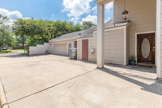 20107 Sunny Shores Dr, Humble, TX 77346 - view of home's exterior featuring concrete driveway, roof with shingles, cooling unit, and an attached garage