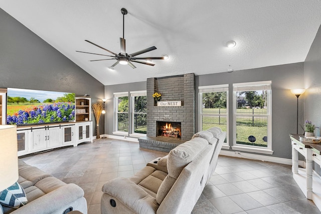 20107 Sunny Shores Dr, Humble, TX 77346 - tiled living room with baseboards, ceiling fan, a fireplace, and high vaulted ceiling