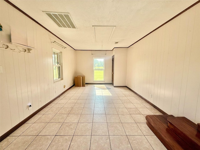 3918 County Road 507, Brazoria, TX 77422 - spare room featuring light tile patterned floors, wood walls, ornamental molding, baseboards, and a textured ceiling