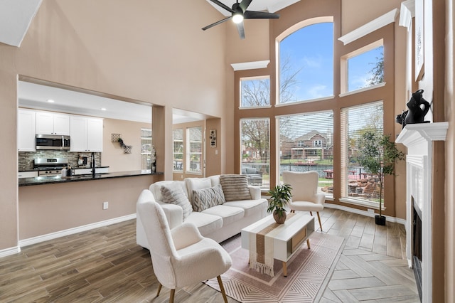 11902 Miramar Shores Dr, Houston, TX 77065 - living area featuring a fireplace, a ceiling fan, a towering ceiling, plenty of natural light, and light wood-type flooring