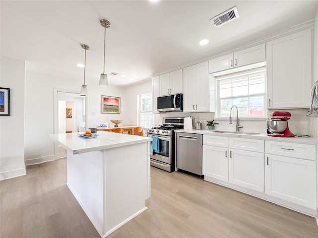 2302 Hewitt Dr, Houston, TX 77018 - kitchen featuring stainless steel appliances, a sink, backsplash, light wood-style flooring, and recessed lighting