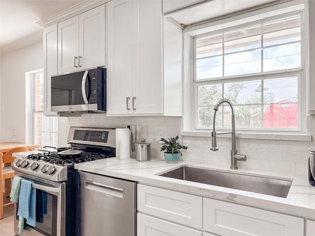 2302 Hewitt Dr, Houston, TX 77018 - kitchen with appliances with stainless steel finishes, a sink, decorative backsplash, and white cabinets