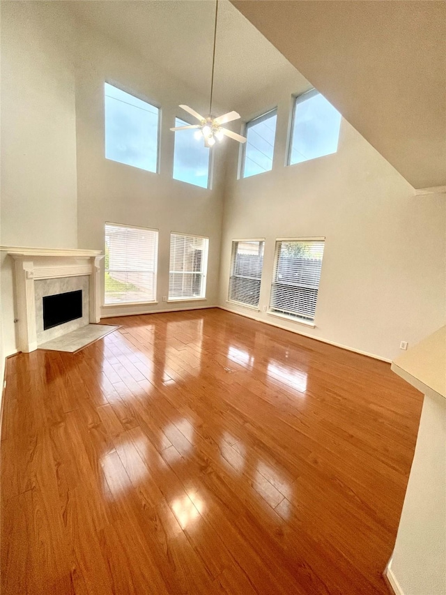 2534 Honeysuckle Walk, Spring, TX 77388 - unfurnished living room featuring ceiling fan, hardwood / wood-style floors, a premium fireplace, and a high ceiling