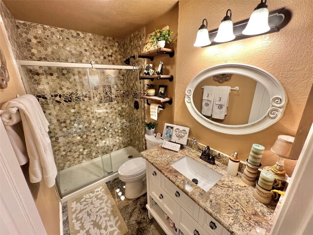 728 S Remington Dr, Angleton, TX 77515 - bathroom with toilet, a shower stall, vanity, marble finish flooring, and a textured ceiling