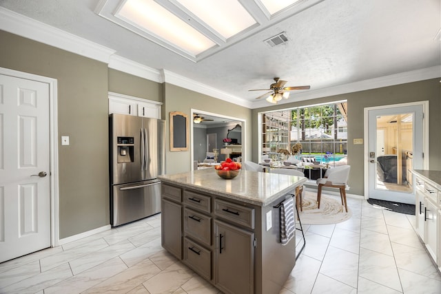 24714 Valleylight Dr, Katy, TX 77494 - kitchen with stainless steel fridge, light marble finish floors, ceiling fan, light stone countertops, and ornamental molding