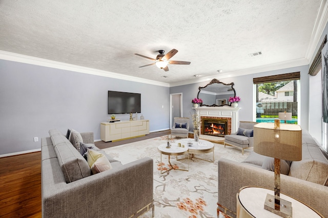 24714 Valleylight Dr, Katy, TX 77494 - living room with ceiling fan, a fireplace, crown molding, a textured ceiling, and wood finished floors