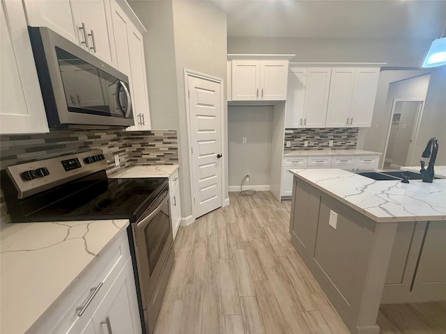 535 Longhorn Trl, Angleton, TX 77515 - kitchen featuring appliances with stainless steel finishes, decorative backsplash, white cabinetry, and a sink