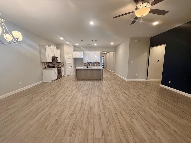535 Longhorn Trl, Angleton, TX 77515 - kitchen featuring open floor plan, stainless steel appliances, white cabinets, backsplash, and a sink