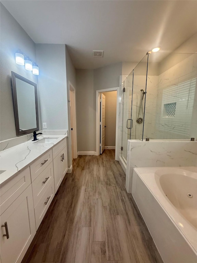 535 Longhorn Trl, Angleton, TX 77515 - full bathroom featuring a whirlpool tub, a shower stall, double vanity, wood finished floors, and baseboards