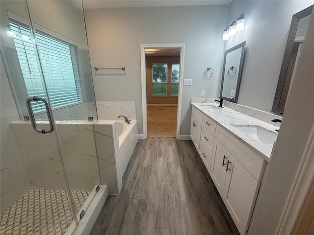 535 Longhorn Trl, Angleton, TX 77515 - bathroom with a bath, double vanity, a marble finish shower, wood finished floors, and baseboards