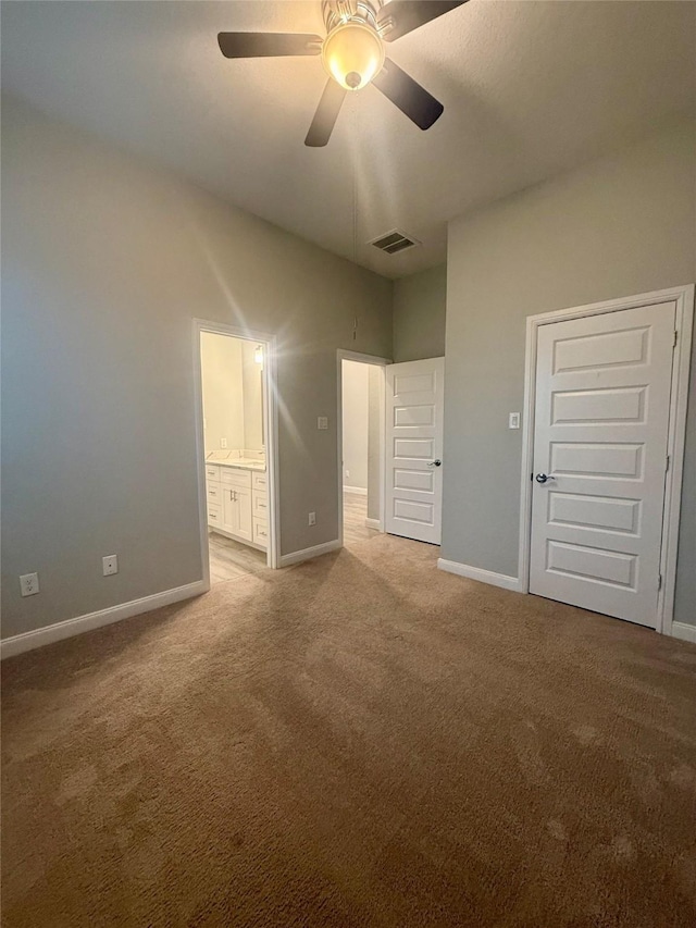 535 Longhorn Trl, Angleton, TX 77515 - unfurnished bedroom with carpet floors, baseboards, ensuite bathroom, and a ceiling fan