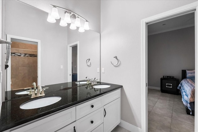 7014 Terrasso Dr, Hitchcock, TX 77563 - full bathroom with double vanity, connected bathroom, baseboards, and tile patterned flooring