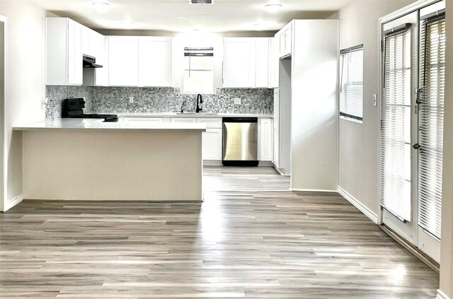 827 Live Oak Dr, Jones Creek, TX 77541 - kitchen featuring stainless steel dishwasher, black range with electric cooktop, under cabinet range hood, a sink, and a peninsula