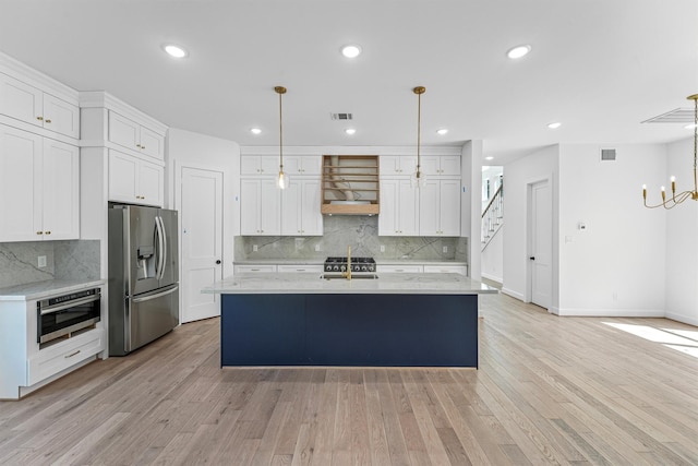 1316 E 34th St, Houston, TX 77022 - kitchen with stainless steel appliances, ventilation hood, white cabinets, decorative backsplash, and recessed lighting