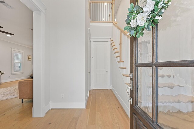 11 Caravelle Ct, Galveston, TX 77554 - foyer entrance with wood finished floors, ornamental molding, baseboards, stairway, and a ceiling fan