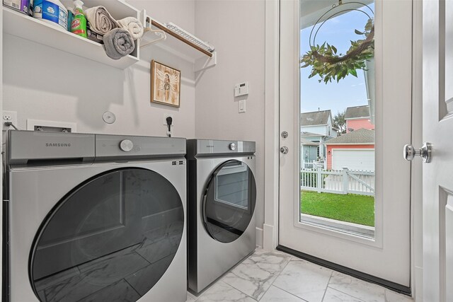 11 Caravelle Ct, Galveston, TX 77554 - laundry room with washer and dryer, light marble finish floors, and plenty of natural light