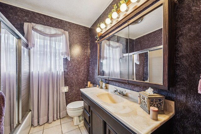 16219 Dundee Rd, Cypress, TX 77429 - full bath featuring tile patterned floors, ornamental molding, vanity, toilet, and wallpapered walls