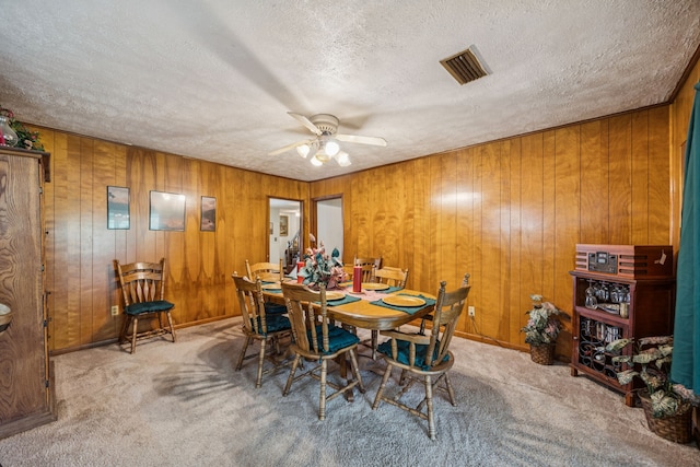 16219 Dundee Rd, Cypress, TX 77429 - carpeted dining space featuring ceiling fan, a textured ceiling, and wood walls