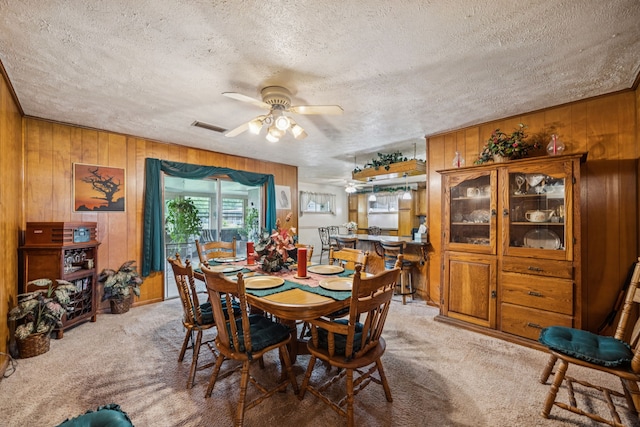 16219 Dundee Rd, Cypress, TX 77429 - carpeted dining area featuring wooden walls, a textured ceiling, and a ceiling fan
