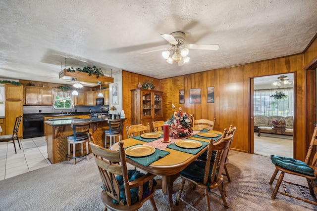 16219 Dundee Rd, Cypress, TX 77429 - dining space featuring plenty of natural light, a textured ceiling, a ceiling fan, wooden walls, and light colored carpet