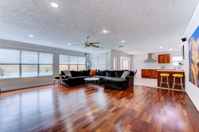5638 Long Creek Ln, Houston, TX 77088 - living area featuring light wood-style floors, a textured ceiling, crown molding, baseboards, and recessed lighting