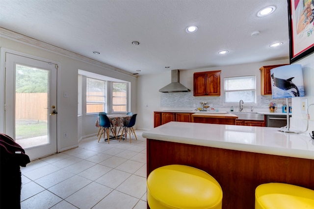 5638 Long Creek Ln, Houston, TX 77088 - kitchen with wall chimney exhaust hood, a sink, a peninsula, light countertops, and tasteful backsplash