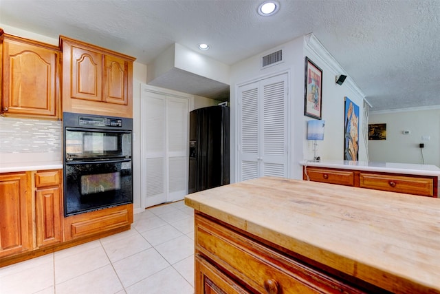 5638 Long Creek Ln, Houston, TX 77088 - kitchen with black appliances, a textured ceiling, light tile patterned floors, decorative backsplash, and brown cabinets