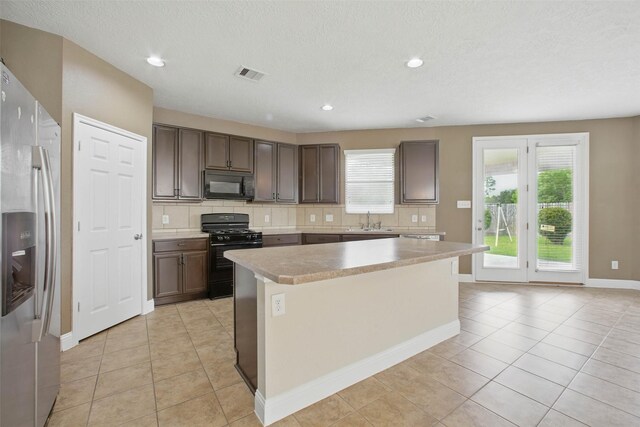 11707 Newel Elm St, Houston, TX 77038 - kitchen with black appliances, decorative backsplash, light countertops, light tile patterned floors, and recessed lighting