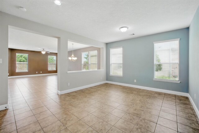 11707 Newel Elm St, Houston, TX 77038 - empty room featuring light tile patterned floors, a chandelier, baseboards, and a textured ceiling