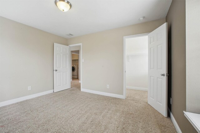 11707 Newel Elm St, Houston, TX 77038 - unfurnished bedroom featuring washer / clothes dryer, carpet, a walk in closet, and baseboards