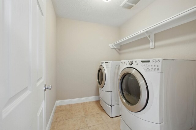11707 Newel Elm St, Houston, TX 77038 - washroom featuring washer and clothes dryer, baseboards, and light tile patterned floors
