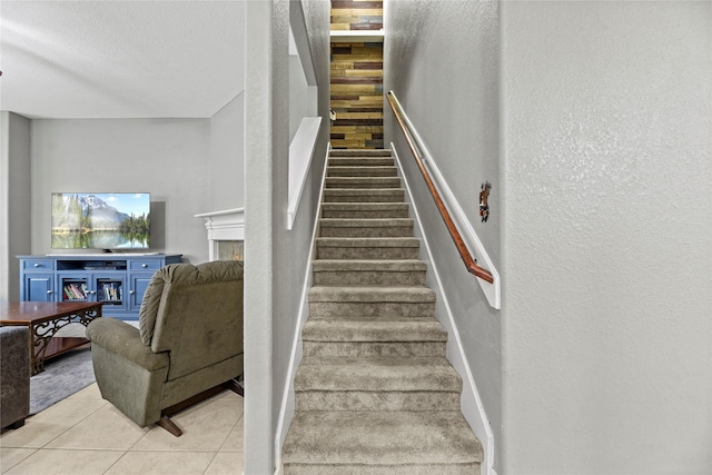 20918 Field Manor Ln, Katy, TX 77450 - stairs with a textured wall, tile patterned flooring, a lit fireplace, a textured ceiling, and baseboards