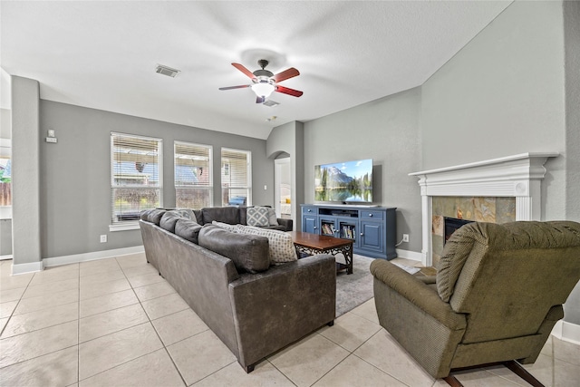 20918 Field Manor Ln, Katy, TX 77450 - living area with ceiling fan, a tile fireplace, light tile patterned floors, arched walkways, and baseboards