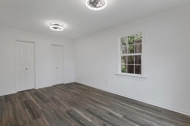639 Manor St, Houston, TX 77015 - unfurnished bedroom with multiple closets, dark wood-style flooring, and baseboards