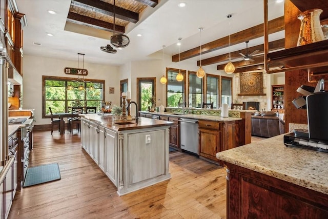535 Creekside Dr, Salado, TX 76571 - kitchen with a large island, stainless steel appliances, beamed ceiling, light wood finished floors, and a ceiling fan