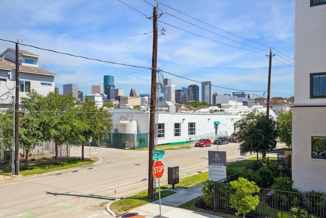 2208 Dennis St, Houston, TX 77004 - view of asphalt street with curbs, sidewalks, a skyline view, and traffic signs