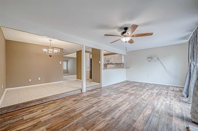 11605 Southlake Dr Unit 32, Houston, TX 77077 - unfurnished living room featuring wood finished floors, a chandelier, a ceiling fan, and baseboards