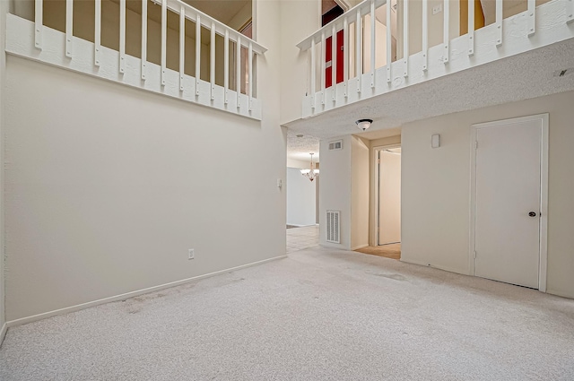 11605 Southlake Dr Unit 32, Houston, TX 77077 - unfurnished living room featuring carpet flooring, a chandelier, and a high ceiling