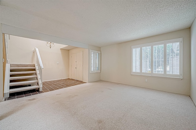 11605 Southlake Dr Unit 32, Houston, TX 77077 - unfurnished living room with carpet floors, plenty of natural light, a textured ceiling, and stairway