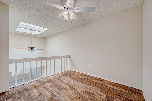 11605 Southlake Dr Unit 32, Houston, TX 77077 - unfurnished room with a skylight, a ceiling fan, wood finished floors, a textured ceiling, and baseboards
