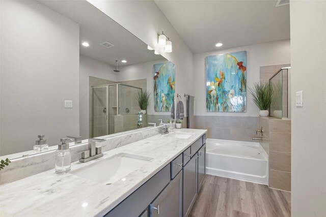 9013 Lonestar Creekbend Ln, Houston, TX 77080 - bathroom featuring a stall shower, double vanity, wood finished floors, a bath, and recessed lighting
