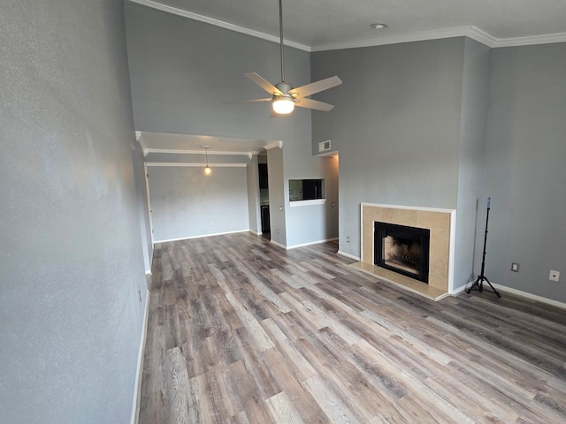 1860 White Oak Dr Unit 314, Houston, TX 77009 - unfurnished living room with crown molding, wood finished floors, a ceiling fan, baseboards, and a fireplace