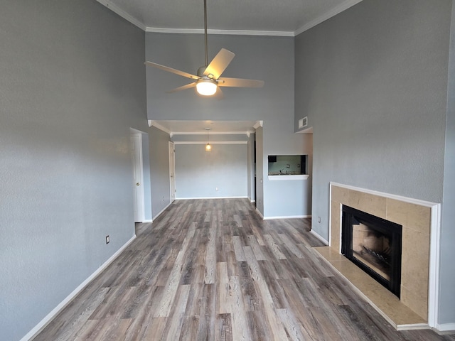 1860 White Oak Dr Unit 314, Houston, TX 77009 - unfurnished living room featuring high vaulted ceiling, ornamental molding, a tile fireplace, ceiling fan, and baseboards