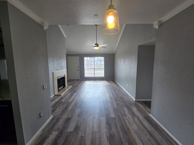 1860 White Oak Dr Unit 314, Houston, TX 77009 - unfurnished living room featuring a textured wall, lofted ceiling, dark wood finished floors, a fireplace with raised hearth, and a textured ceiling