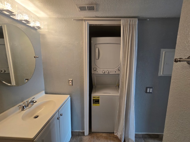 1860 White Oak Dr Unit 314, Houston, TX 77009 - bathroom featuring estacked washer and dryer, electric panel, vanity, tile patterned flooring, and a textured ceiling