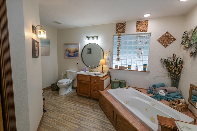4746 County Road 502d, Sweeny, TX 77480 - full bath with a whirlpool tub, vanity, toilet, wood finished floors, and baseboards
